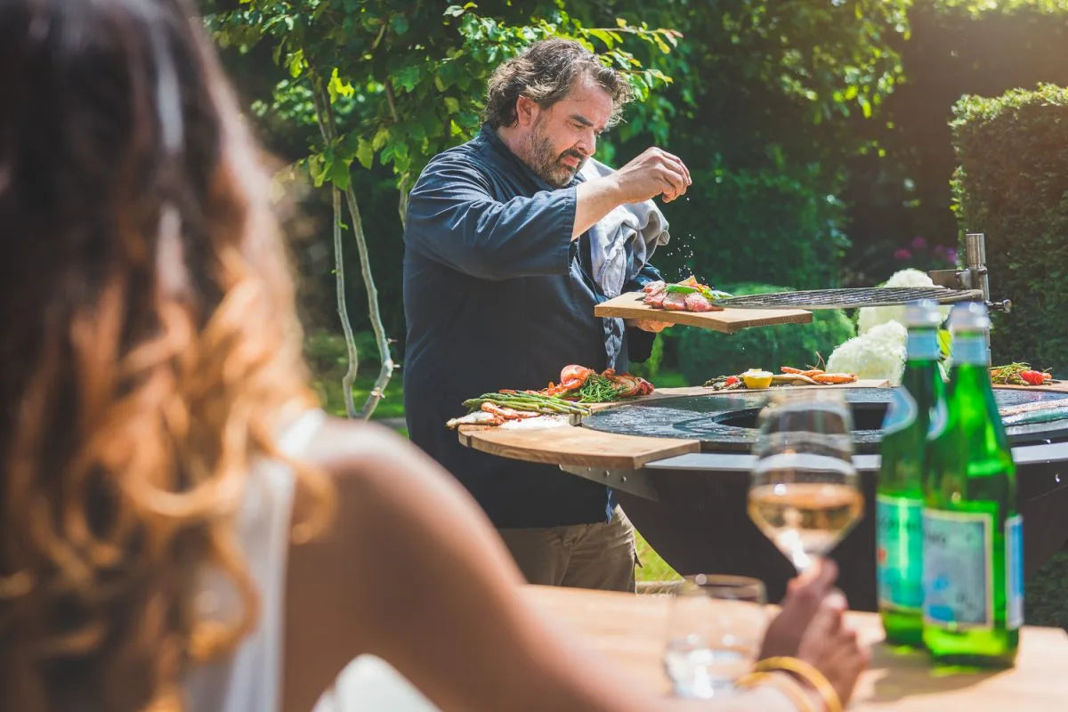 Plancha brasero acier noir rond Ø104 cm avec colonne – FIQ XL dans un jardin