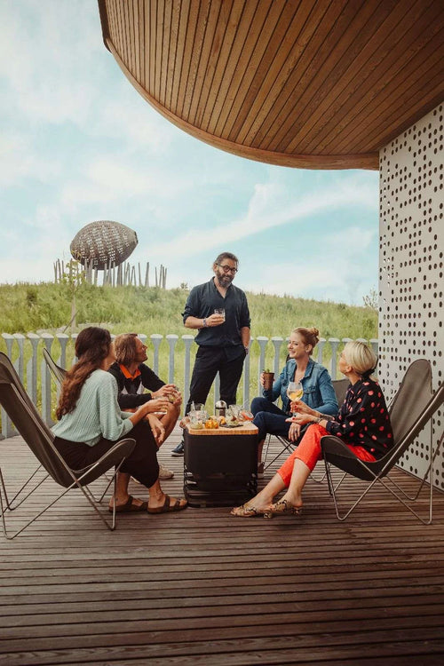 Fauteuil lounge en cuir noir avec structure en métal et siège rembourré, conçu pour la relaxation en extérieur.
