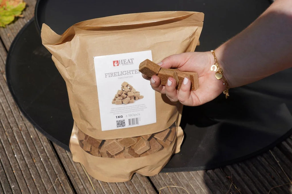 Main de la main tenant allume-feu bois cube barbecue inodore 1-5kg