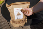 Main de la main tenant allume-feu bois cube barbecue inodore 1-5kg