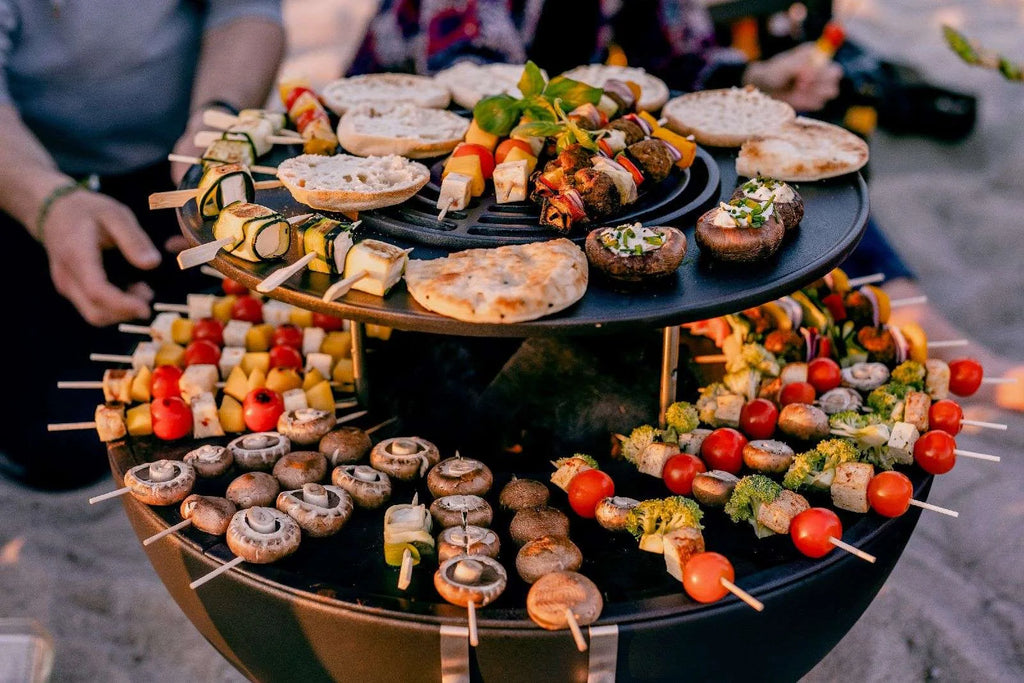 Barbecue grill noir à trois niveaux avec brochettes et articles alimentaires