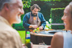 Barbecue extérieur en acier inoxydable avec surface de cuisson noire et accents argentés.