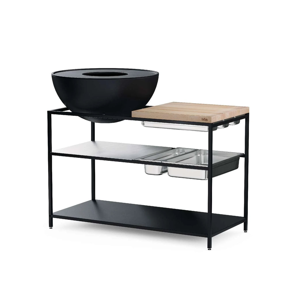 Support-grill en métal noir avec planche à découper en bois et plateau en verre, design moderne.