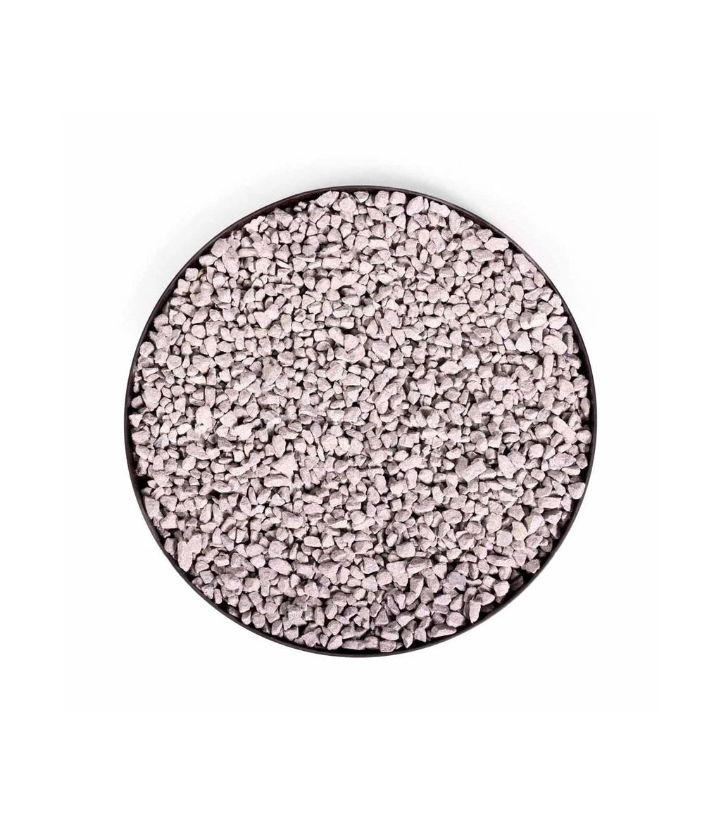 Perles polymères granulaires blanches dans un récipient circulaire noir.
