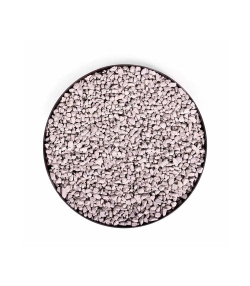 Perles polymères granulaires blanches dans un récipient circulaire noir.