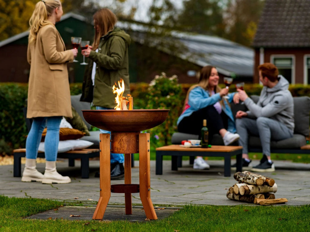Foyer de feu en cuivre rustique avec des pieds en bois et un design de bol circulaire