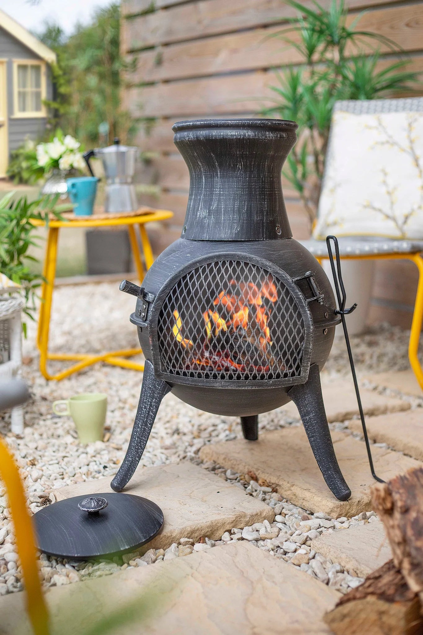 Chimenea en fer forgé noir avec devant en maille et pieds trépied