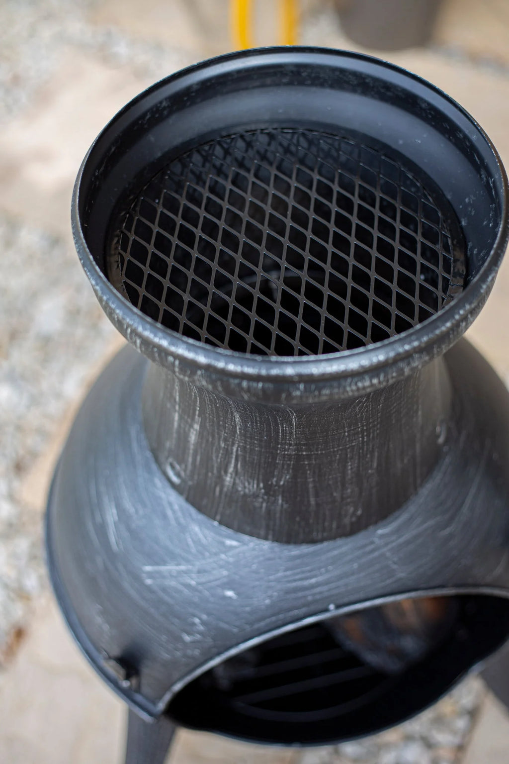 Foyer de feu en métal noir avec une grille en maille et une surface texturée