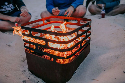 Fosse de feu avec grille métallique orange et base noire, conçue pour un usage extérieur.