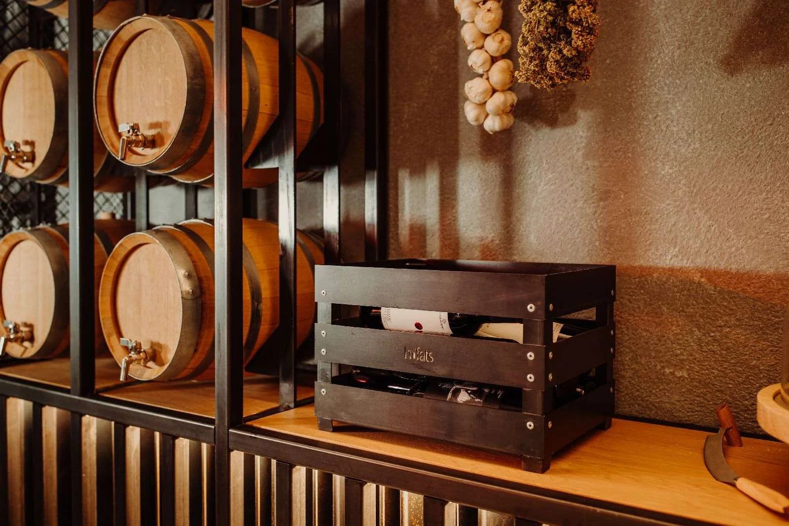 Caisse en bois sombre pour vin avec accents métalliques et logo gravé.