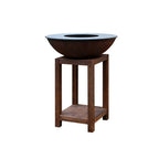 Bol en acier brun rouillé avec un rebord intérieur lisse bleu foncé repose sur un support en bois assorti.