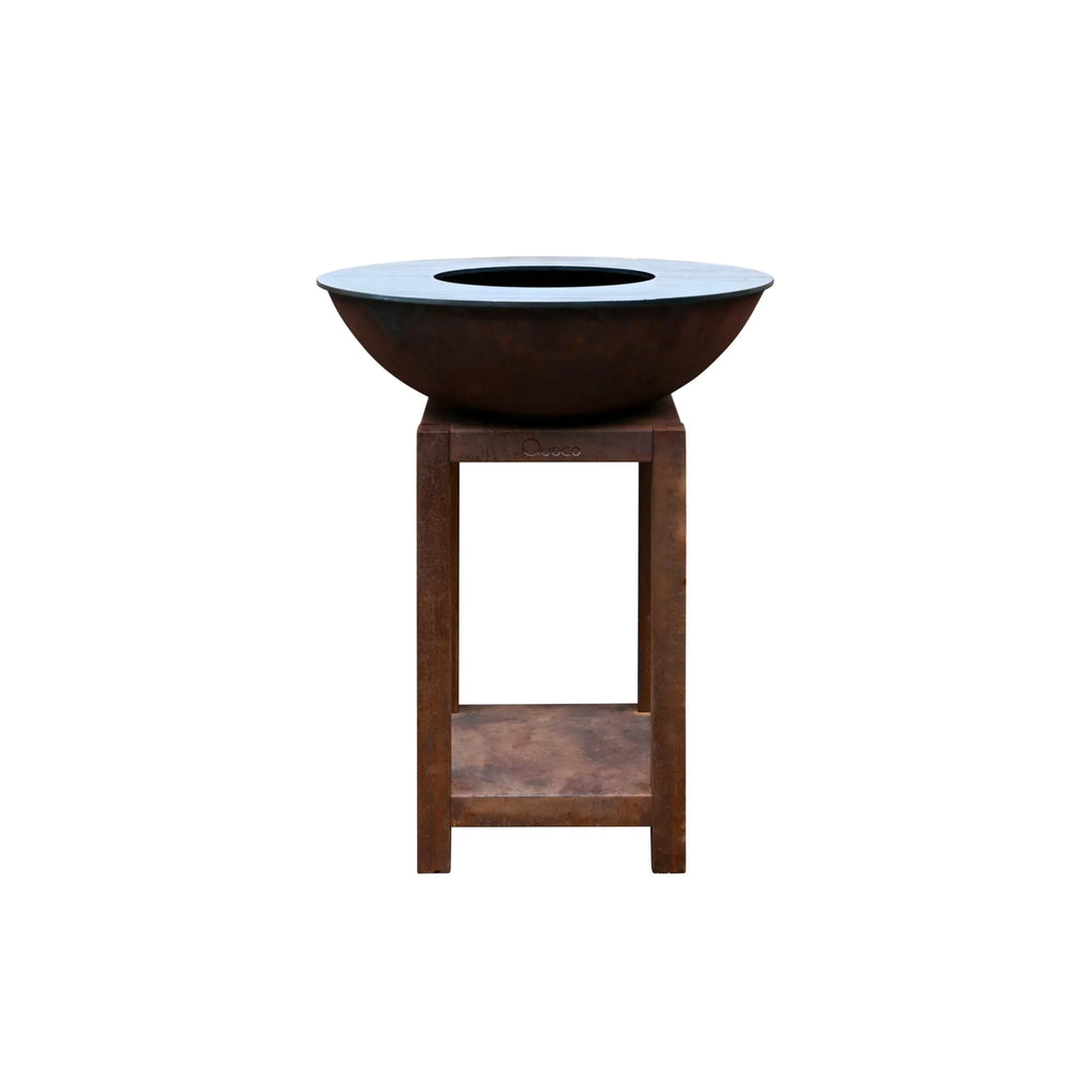 Bol en acier brun rouillé avec un intérieur noir lisse, monté sur un support en bois robuste.