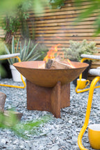 Foyer de feu en acier rouillé de couleur rouille avec un design moderne et minimaliste et une base sur trépied