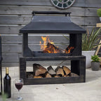 Foyer de feu extérieur en métal noir avec un toit et un compartiment de rangement inférieur rempli de bûches