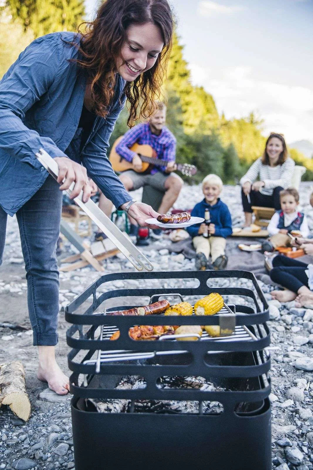 Barbecue au charbon avec cadre et grille en métal noir, conçu pour la cuisson en extérieur.