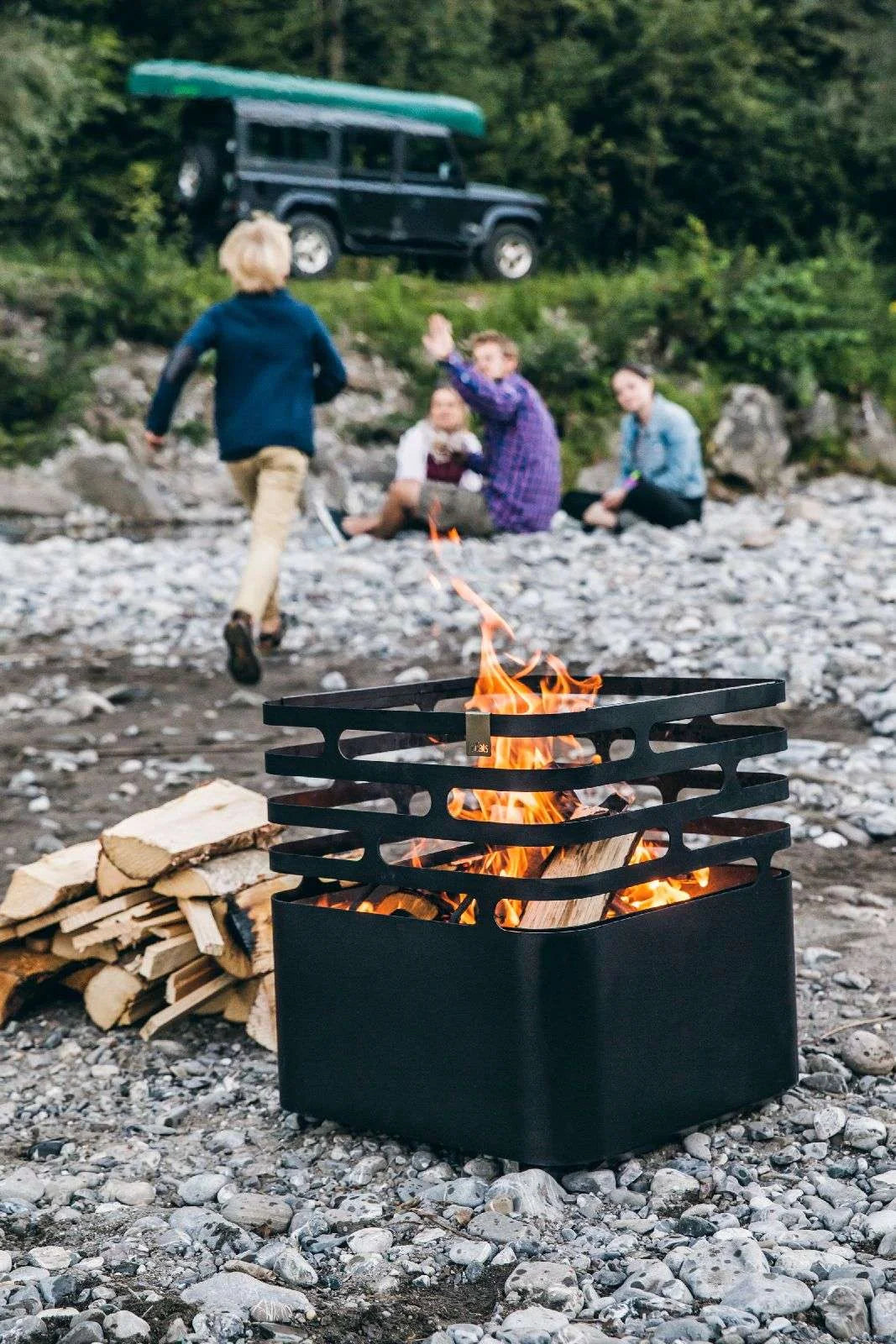 Foyer de feu en métal noir avec design de grille circulaire et flammes
