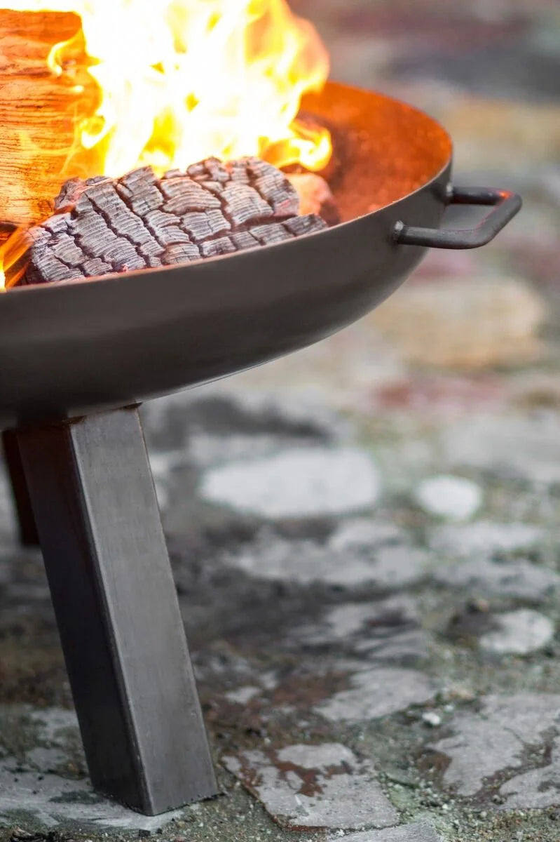 Barbecue au charbon avec bol en fonte noire et pieds en métal robustes.