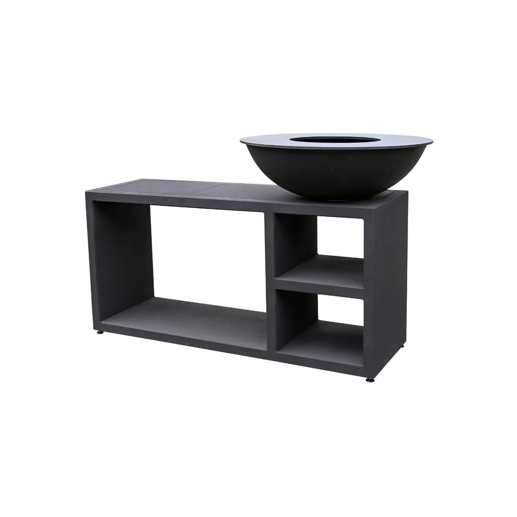 Bol en fonte noire reposant sur une table console extérieure assortie en gris foncé avec étagères ouvertes.