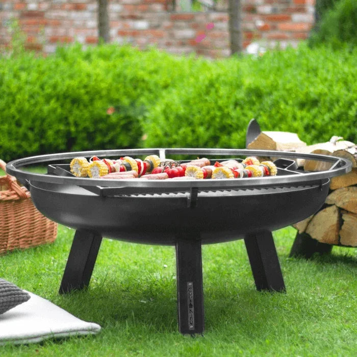 Barbecue de foyer à feu noir avec pieds en métal et grille de cuisson, conçu pour la grillade en extérieur.