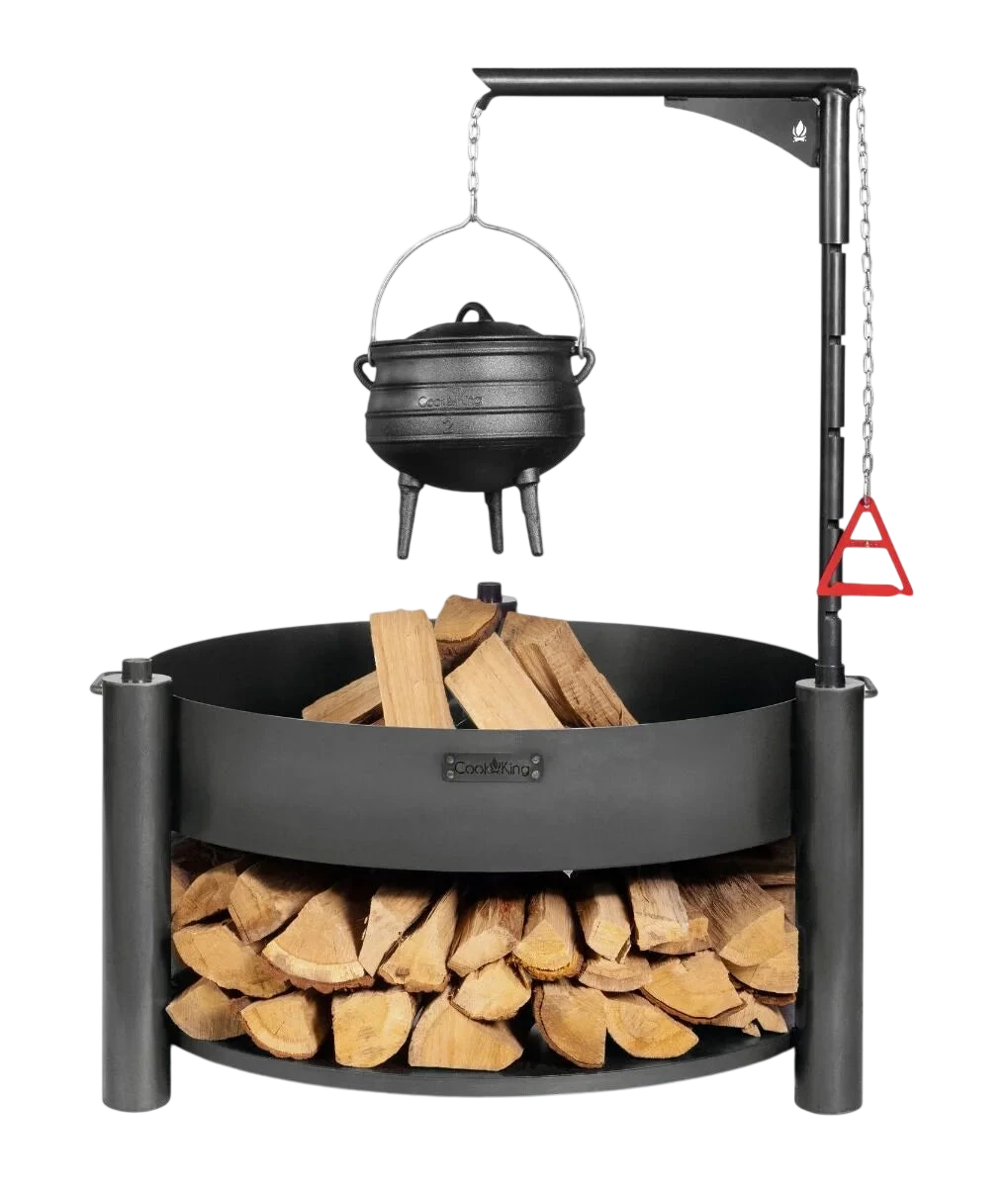 Foyer de feu en fonte noire avec support de pot suspendu et base de rangement pour bois.