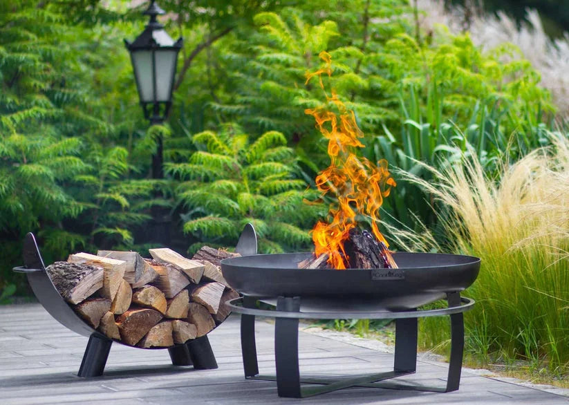 Foyer de feu noir avec des flammes orange et des bûches en bois.