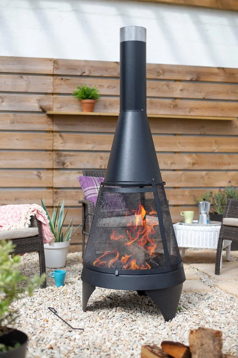 Foyer de feu en métal noir avec un design conique et un écran en maille, doté d’une cheminée surmontée d’argent.