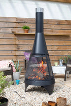 Foyer de feu en métal noir avec un design conique et un écran en maille, doté d’une cheminée surmontée d’argent.