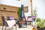 Foyer de feu en métal noir avec un design conique et des côtés en maille, présentant une flamme active à l’intérieur
