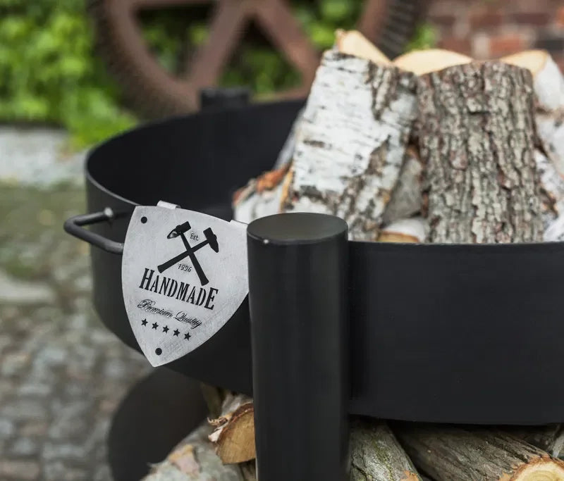 Marmite en fonte noire avec étiquette « fait main » et design de marteaux croisés.