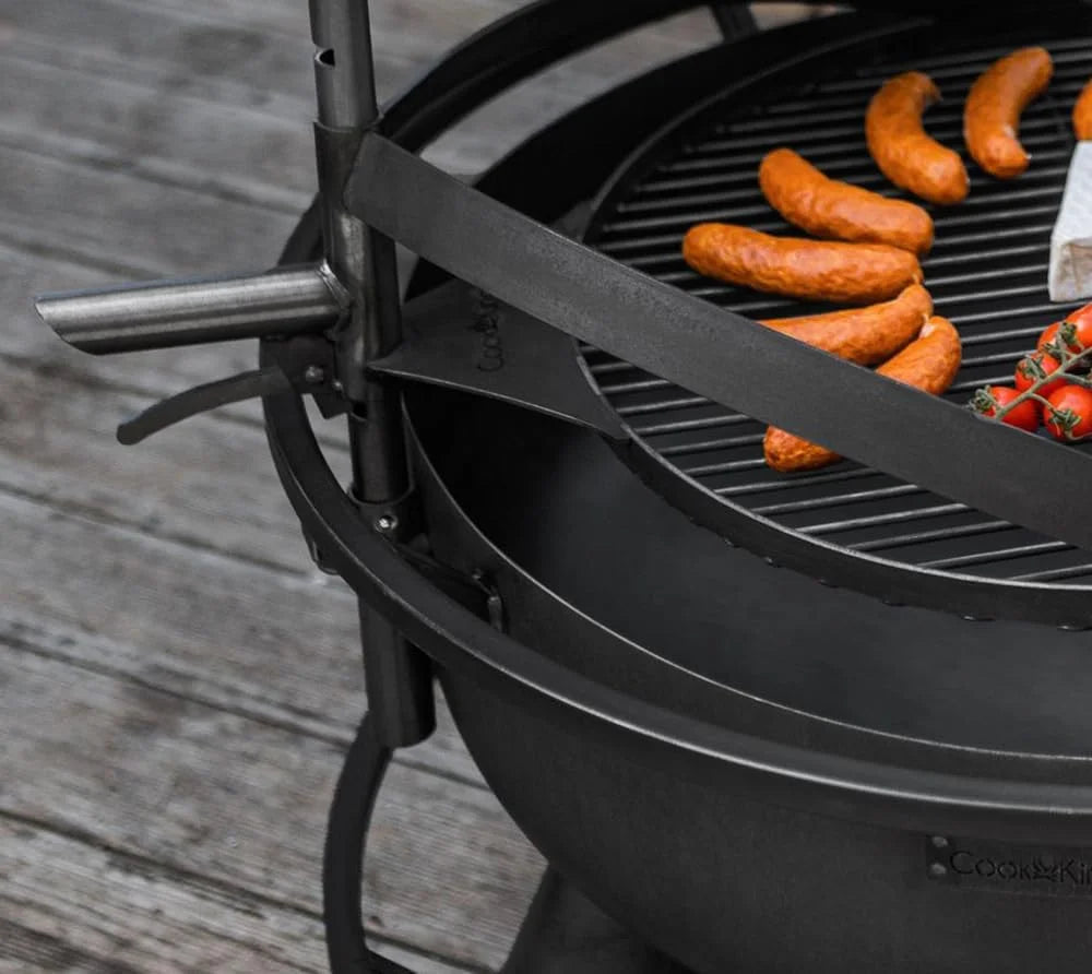 Barbecue au charbon avec grille métallique et poignée, de couleur noire.