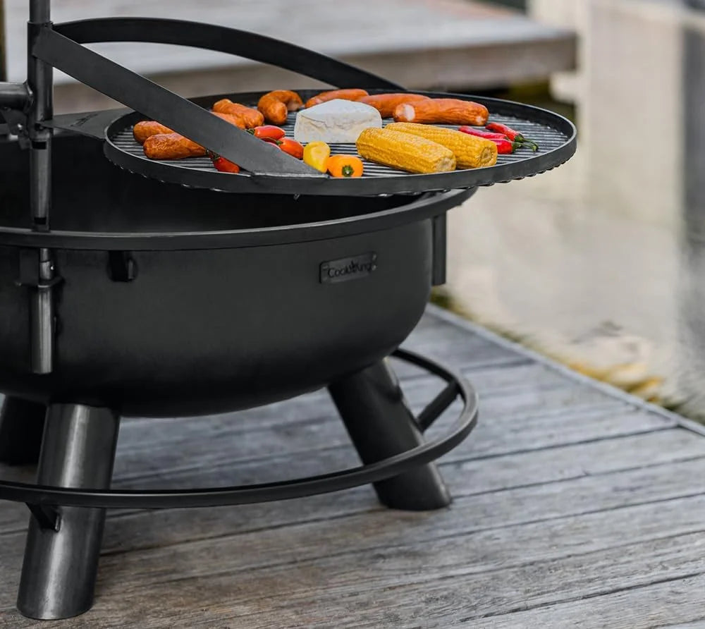 Barbecue au charbon avec surface de cuisson en fonte noire et pieds en métal robustes.