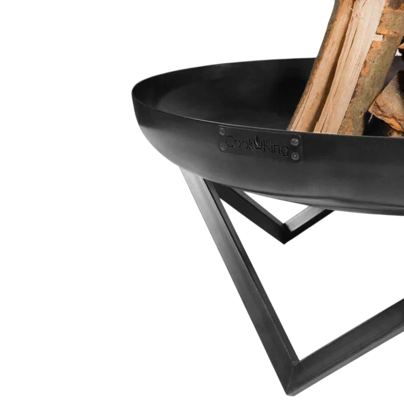 Foyer de feu en métal noir avec pieds courbés et compartiment de rangement pour bois