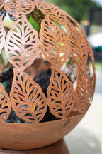 Foyer en métal rouille avec des découpes en forme de feuilles intricées.