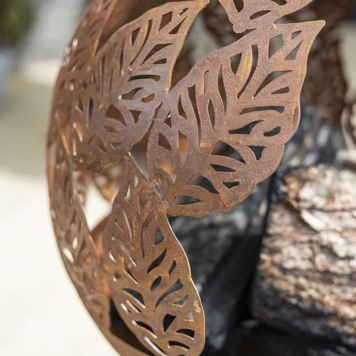 Sculpture en feuilles de métal de couleur cuivre rustique avec des motifs découpés intricats.