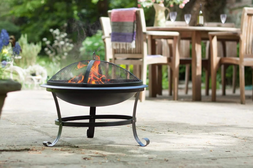 Foyer de feu en fer forgé noir avec couvercle en maille et flamme à l’intérieur