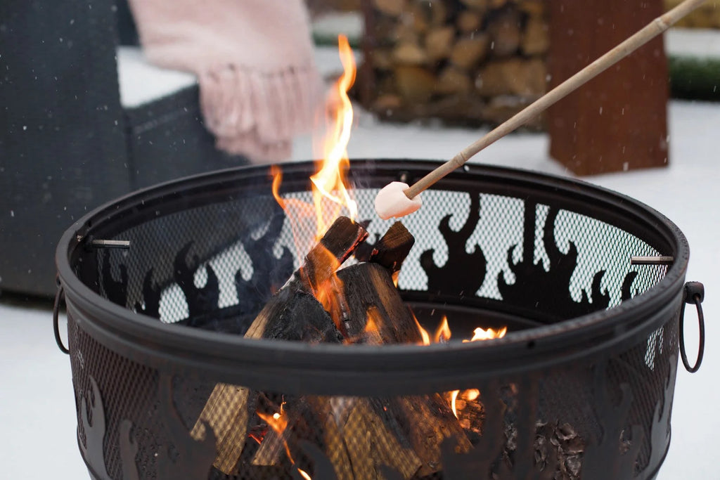 Foyer de feu en métal noir avec découpes en forme de flamme et un intérieur en maille