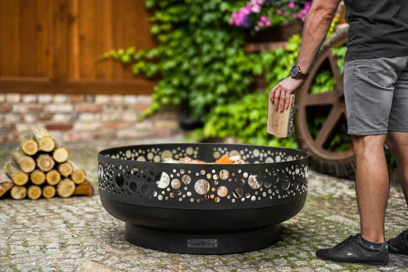 Foyer de feu en métal noir avec des motifs découpés intricés et un design moderne, inspiré de la marque « Blaze » connue pour le mode de vie en extérieur.
