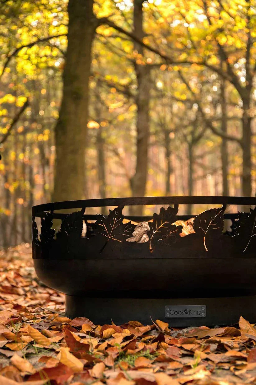 Foyer de feu en métal noir avec motif de feuilles, usage extérieur.