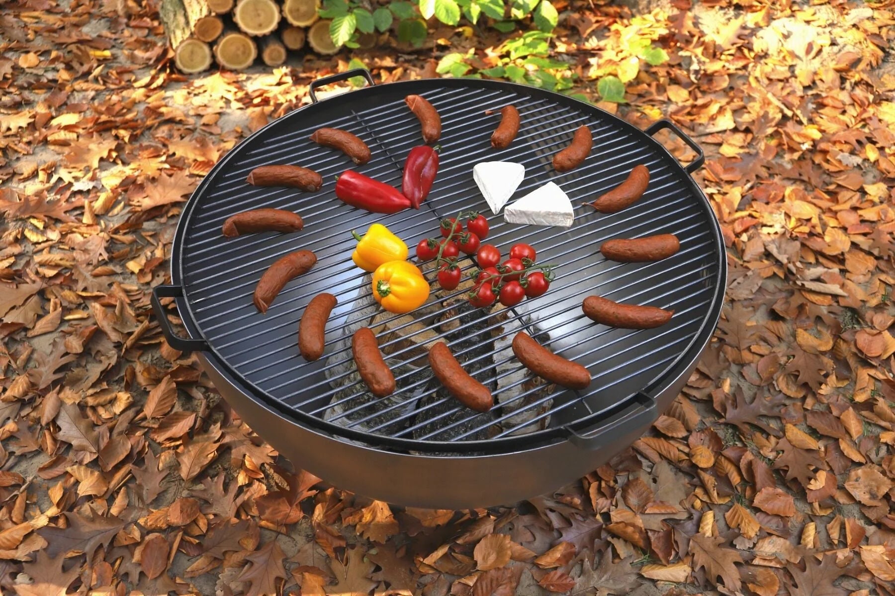 Barbecue au charbon avec grille et poignées noires, entouré de feuilles d’automne.barbecue au charbon avec grille et poignées noires entouré de feuilles d’automne.