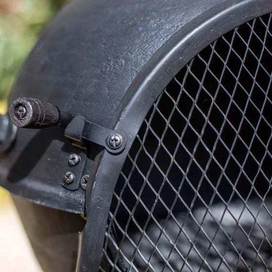 Casque d’émeute en métal noir avec une visière de protection en maille à motif diamanté.