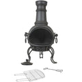 Cheminée en fonte noire forgée avec un devant en maille, quatre pieds courbés et une cheminée attachée.