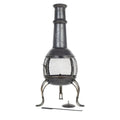 Chimenea en fonte noire avec un écran en maille et des pieds courbés décoratifs.