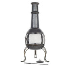 Chimenea en fonte noire avec un écran en maille et des pieds courbés décoratifs.