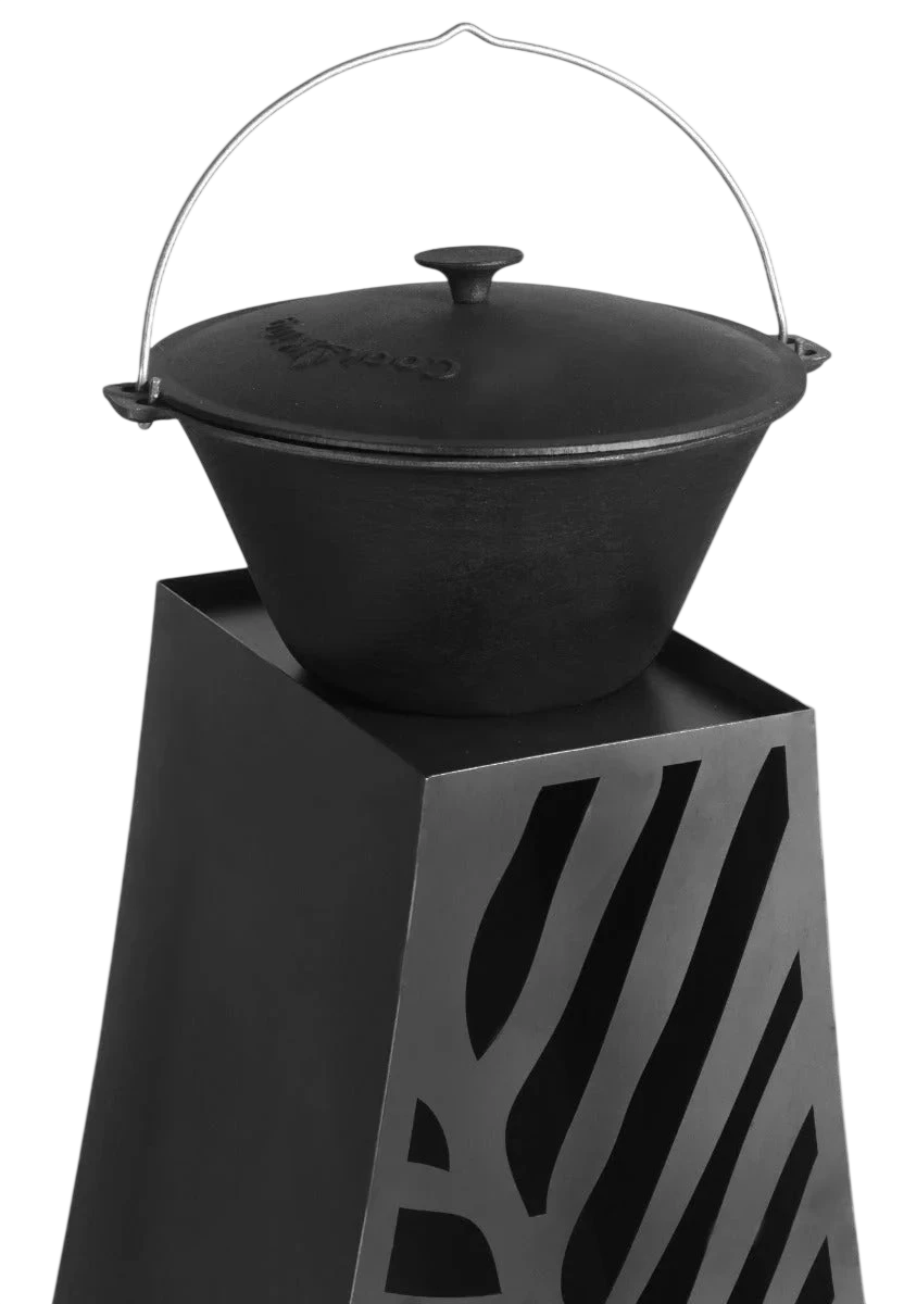 Autocuiseur en fonte noire avec une poignée en fil de fer et un design de découpe géométrique sur le support.