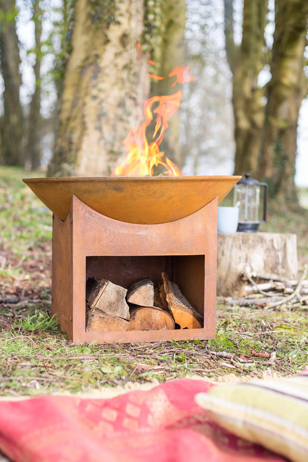 Foyer de feu rustique de couleur cuivre avec un bol supérieur courbé et un compartiment de rangement en dessous