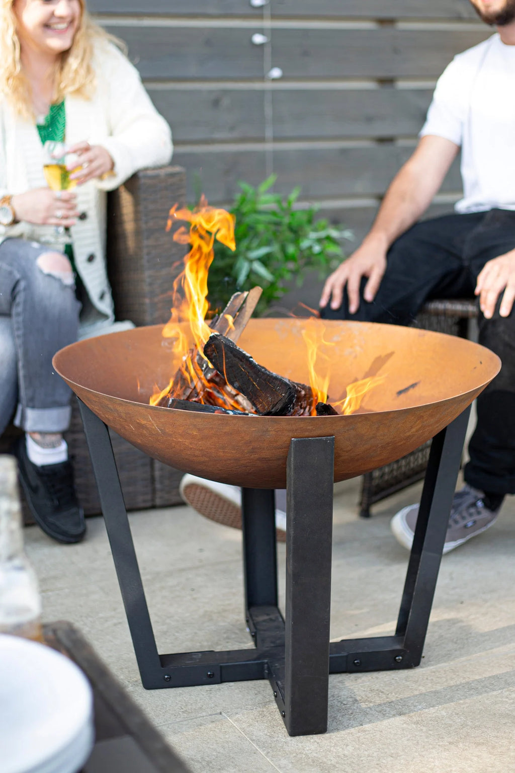 Foyer de feu en acier rouillé avec des pieds en métal noir