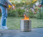 Brûleur cylindrique pour feu de camp en acier inoxydable avec un design élégant et moderne et le nom de marque ’redfire’ gravé sur son côté.