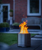 Foyer cylindrique en acier inoxydable avec une flamme orange vibrante s’élevant de son sommet.