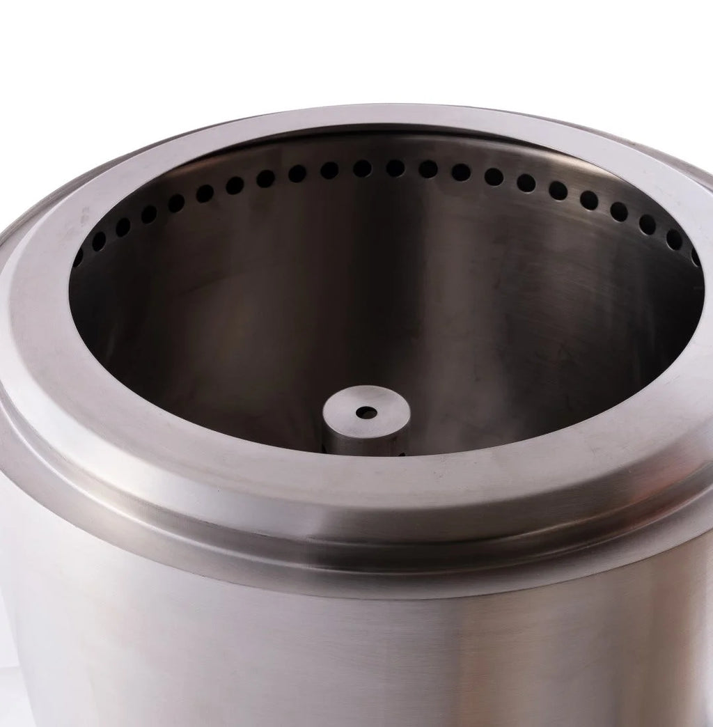 Foyer de feu cylindrique en acier inoxydable avec un rebord circulaire présentant des perforations espacées uniformément et un trou d’allumage central.