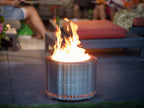 Un foyer de feu cylindrique élégant en acier inoxydable avec un design moderne et une base perforée, de marque « redfire ».
